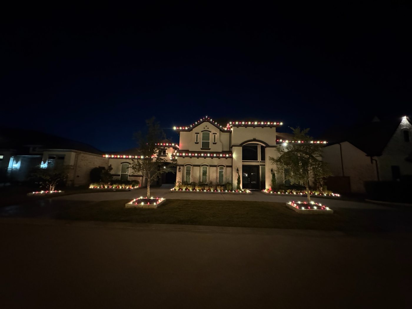Whole-house display with the roofline, beds and driveway edge all lit